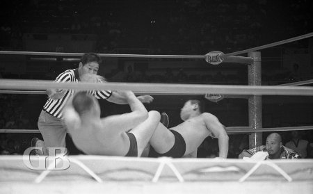 Referee counts as both wrestlers try to get up off the mat.