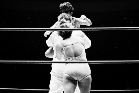 Referee Frank Merril gets caught between the two wrestlers.