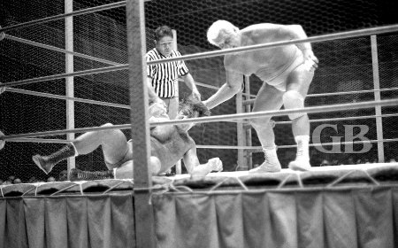 Fred Blassie works over Ed Francis in the chicken wire covered ring.